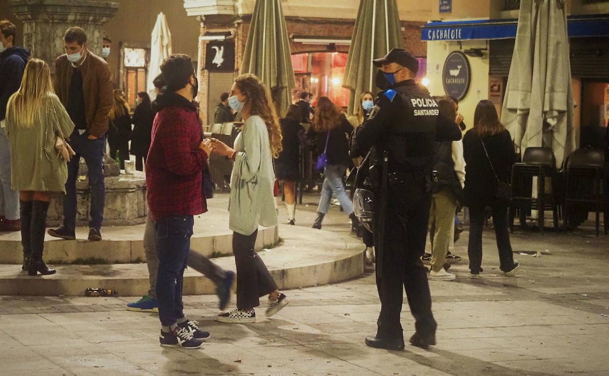 Agentes de la Policía Local de Santander vigilan el cumplimiento de las normas sanitarias durante la noche en la Plaza de Cañadío.