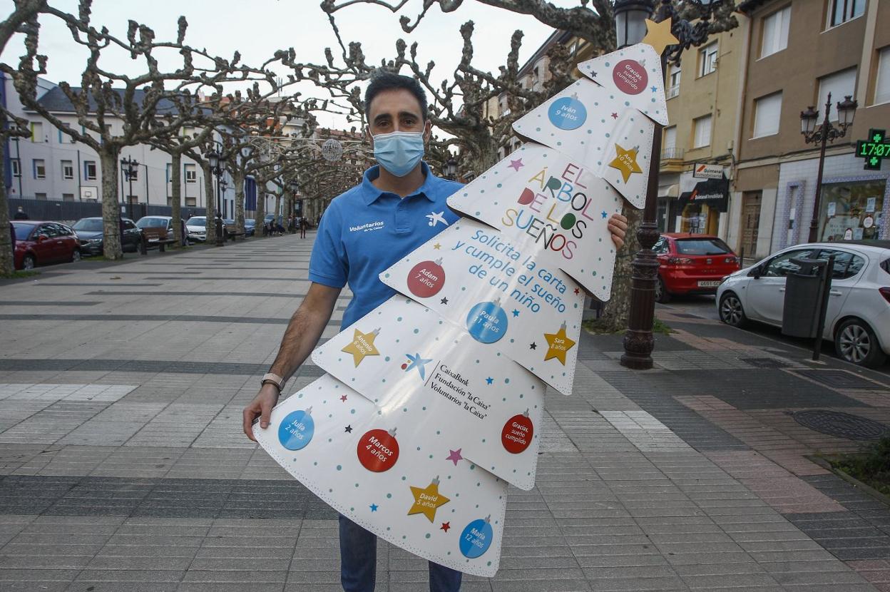 Lorenzo Berrazueta, con uno de los 'arboles de los sueños', en la avenida de España, de Torrelavega. 