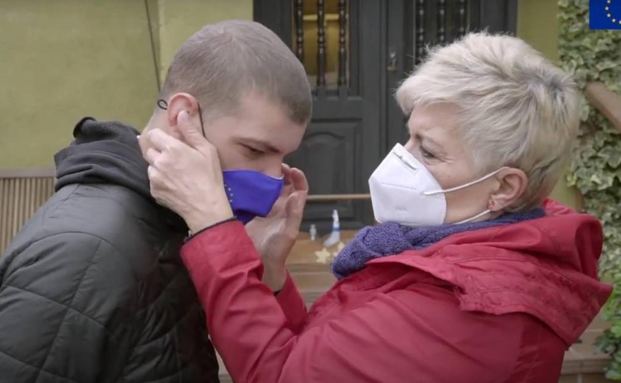 Amparo coloca la mascarilla a su hijo Javier.