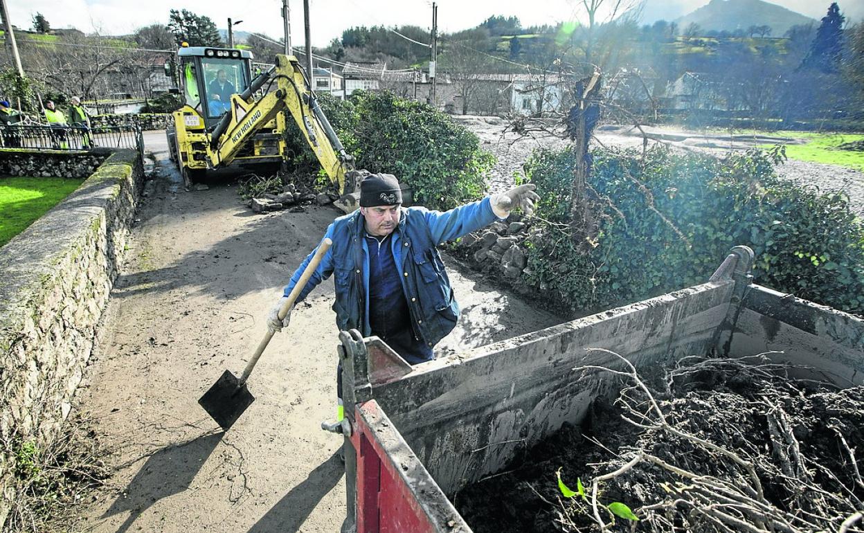 Un trabajador retira restos de las inundaciones en Santa Olalla. 