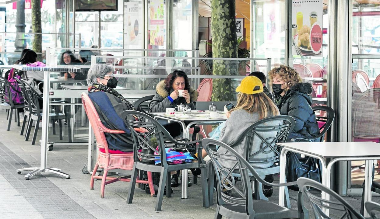 Imagen de un grupo de personas en una terraza del Paseo de Pereda antes de la llegada del temporal. 