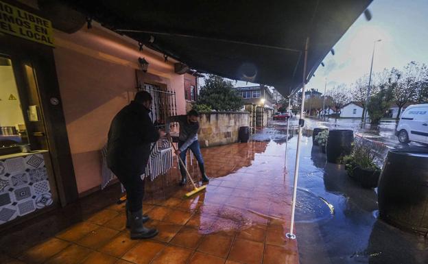 Imagen. Vecinos limpiando las entradas de sus casas.