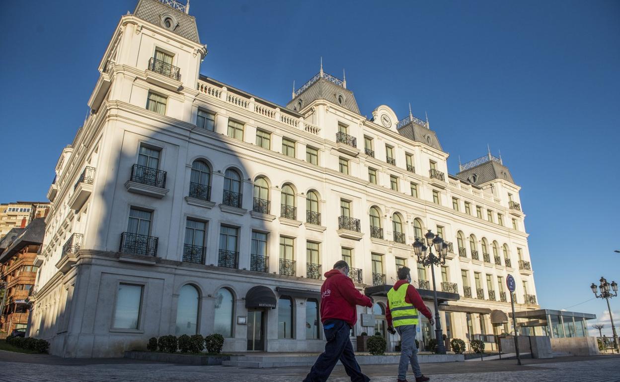Dos personas pasan por delante del Hotel Sardinero, cerrado estos días. Ofrecen a sus clientes alojarse en el Hotel Bahía, que sí está abierto.