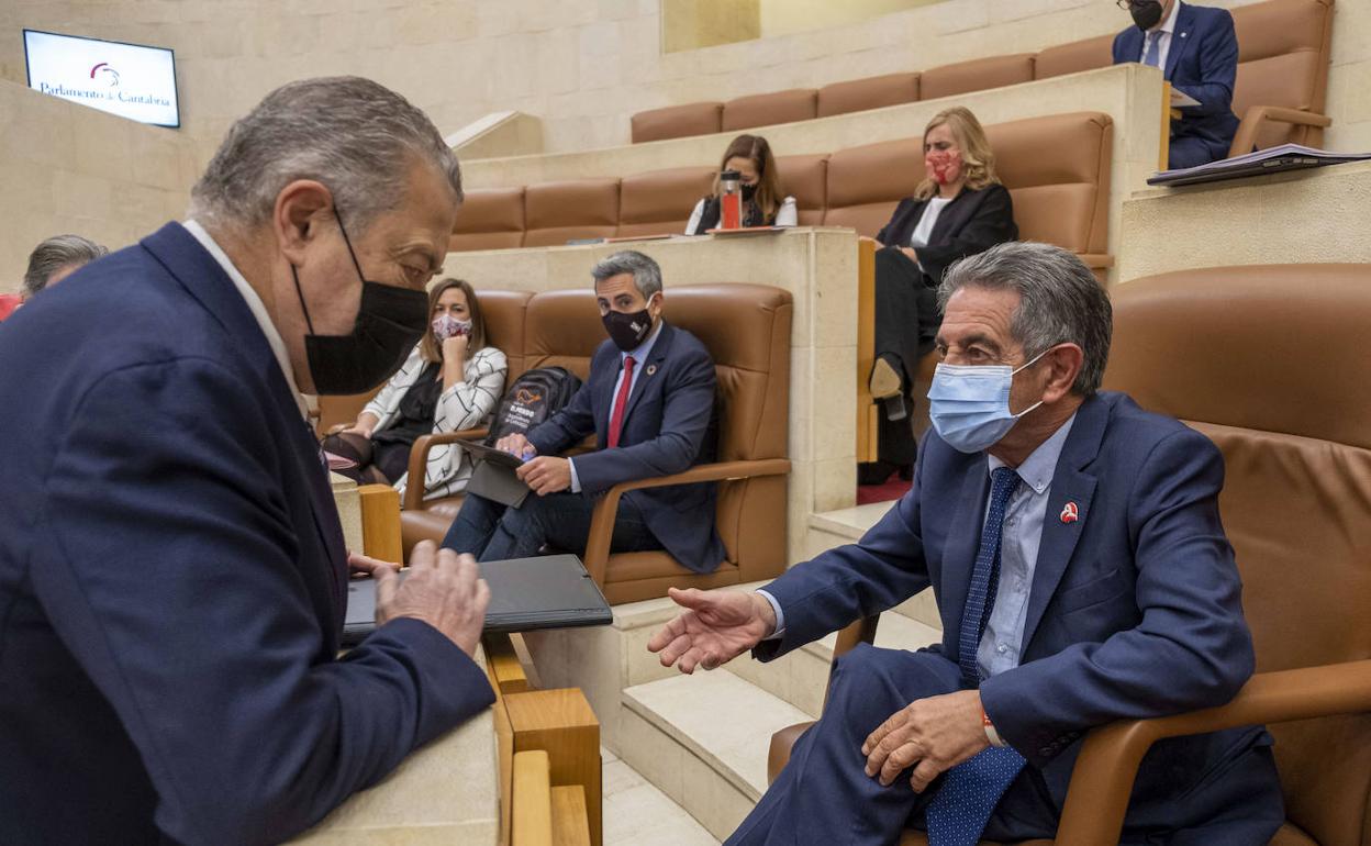 Miguel Ángel Revilla conversa con el presidente de la Cámara, Joaquín Gómez, antes de comenzar el pleno.