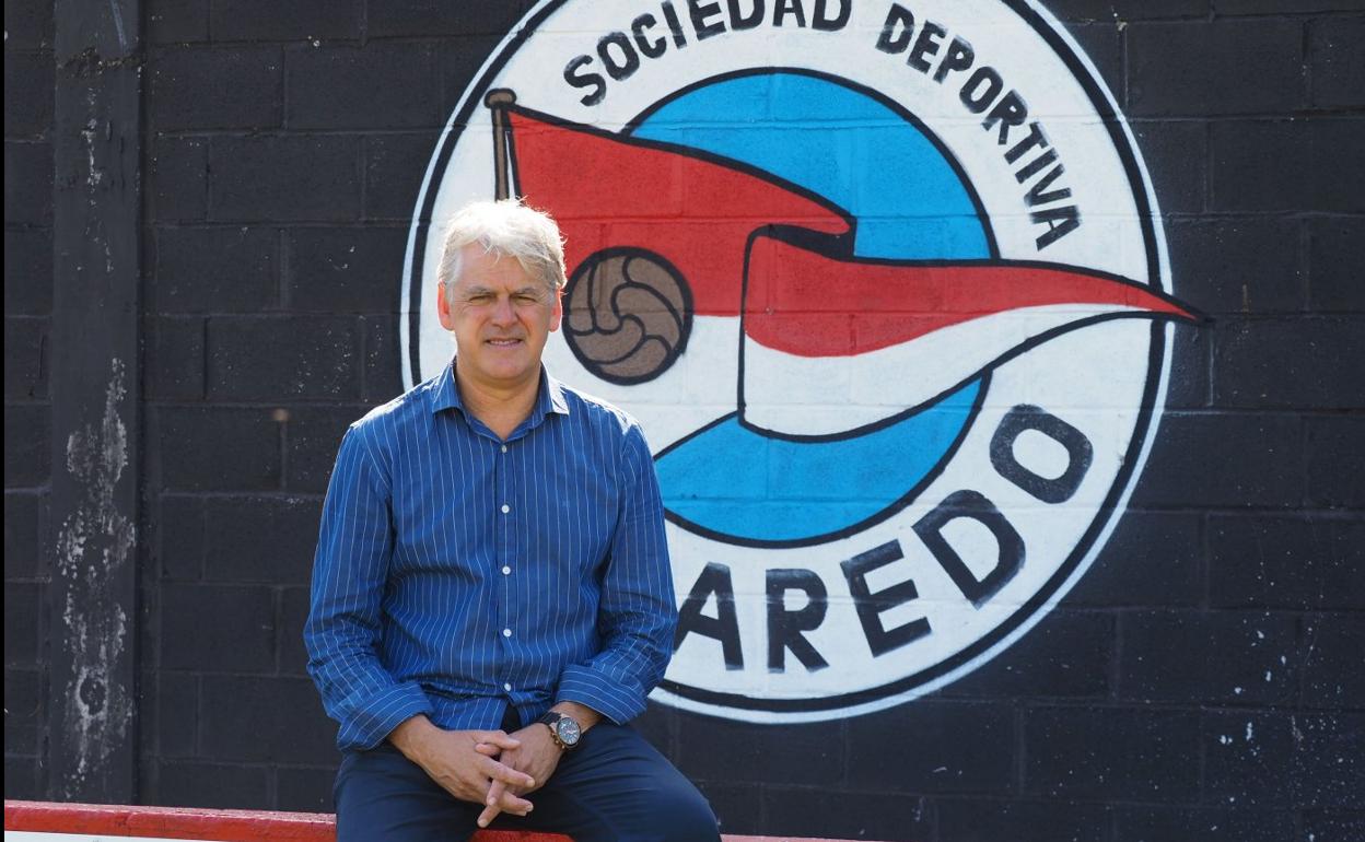 Manu del Valle, director deportivo del Laredo, posa frente al escudo del club. sane