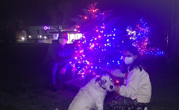 La familia Cagigal, de Pontones, ante el despliegue de luces que han realizado en su jardín 