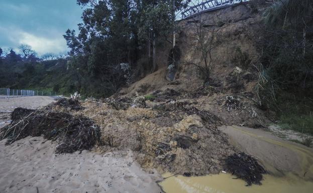 El desprendimiento cubrió el paseo de la playa y los operarios tuvieron que trabajar en el refuerzo del vallado que quedó sepultado bajo la tierra. 