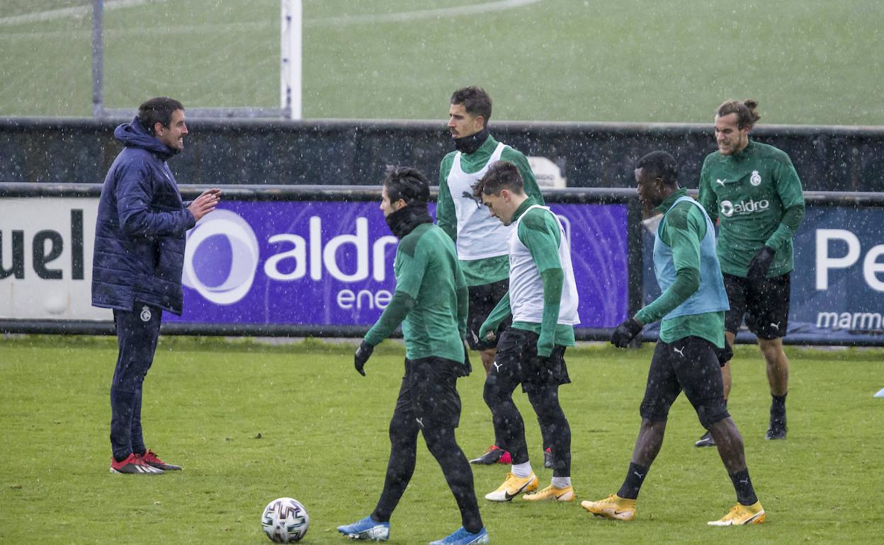 Solabarrieta se dirige bajo la lluvia a Martín Solar, Ceballos y Villapalos, en primera línea, durante un entrenamiento de esta semana en La Albericia. 