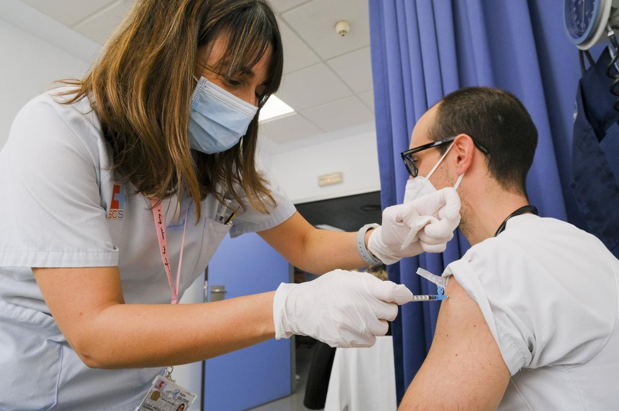 Una enfermera de Valdecilla, esta semana, mientras administra la vacuna contra el covid a un profesional del hospital.