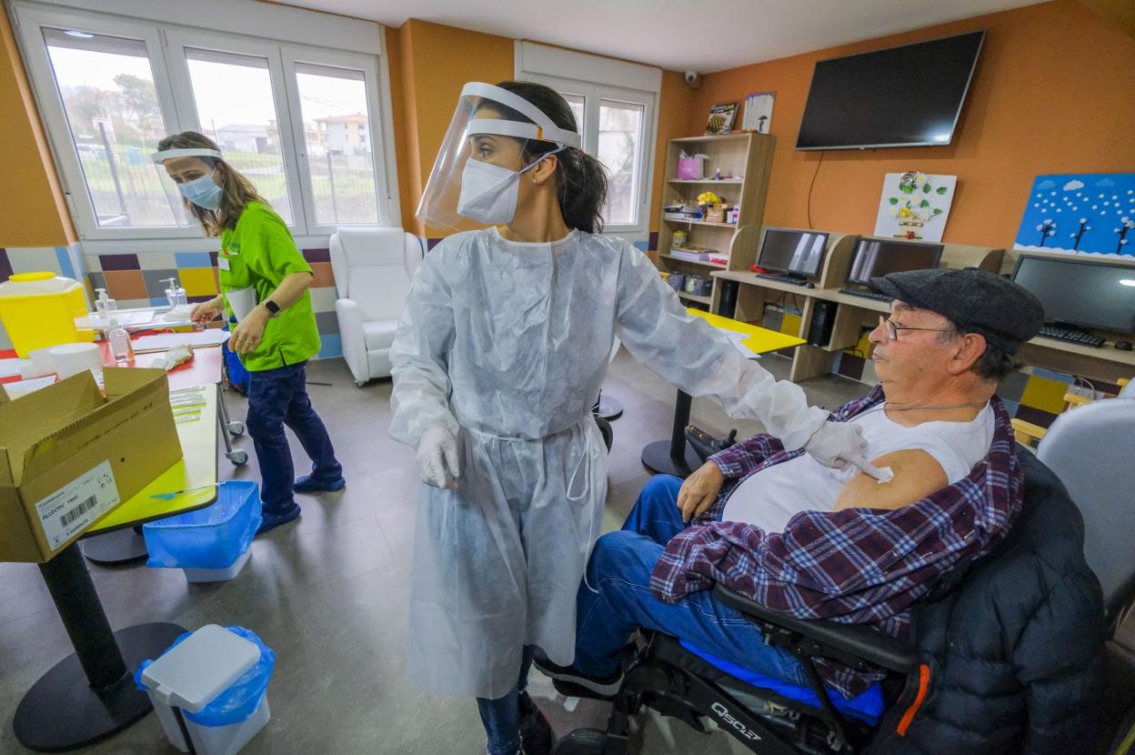 Una enfermera del centro de salud de Ajo administra la vacuna contra el covid a un residente del CAD San Miguel, en Meruelo, esta semana. 