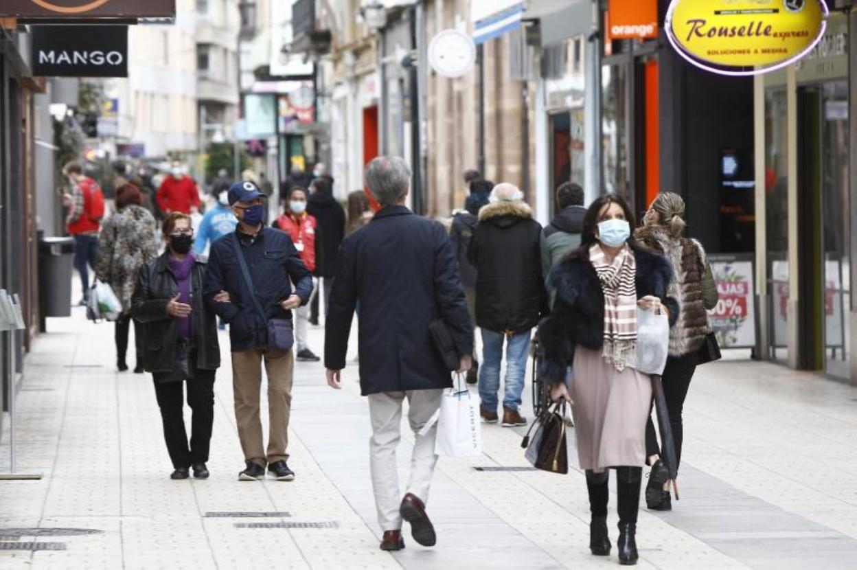 Numerosos ciudadanos caminan por una calle peatonal del centro de Torrelavega. 