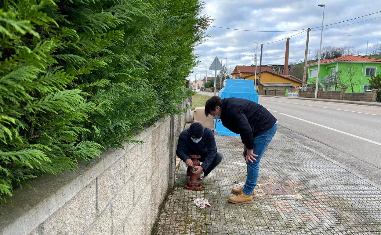 Uno de los concejales, en compañía de un bombero profesional, comprueba el estado de una boca. 