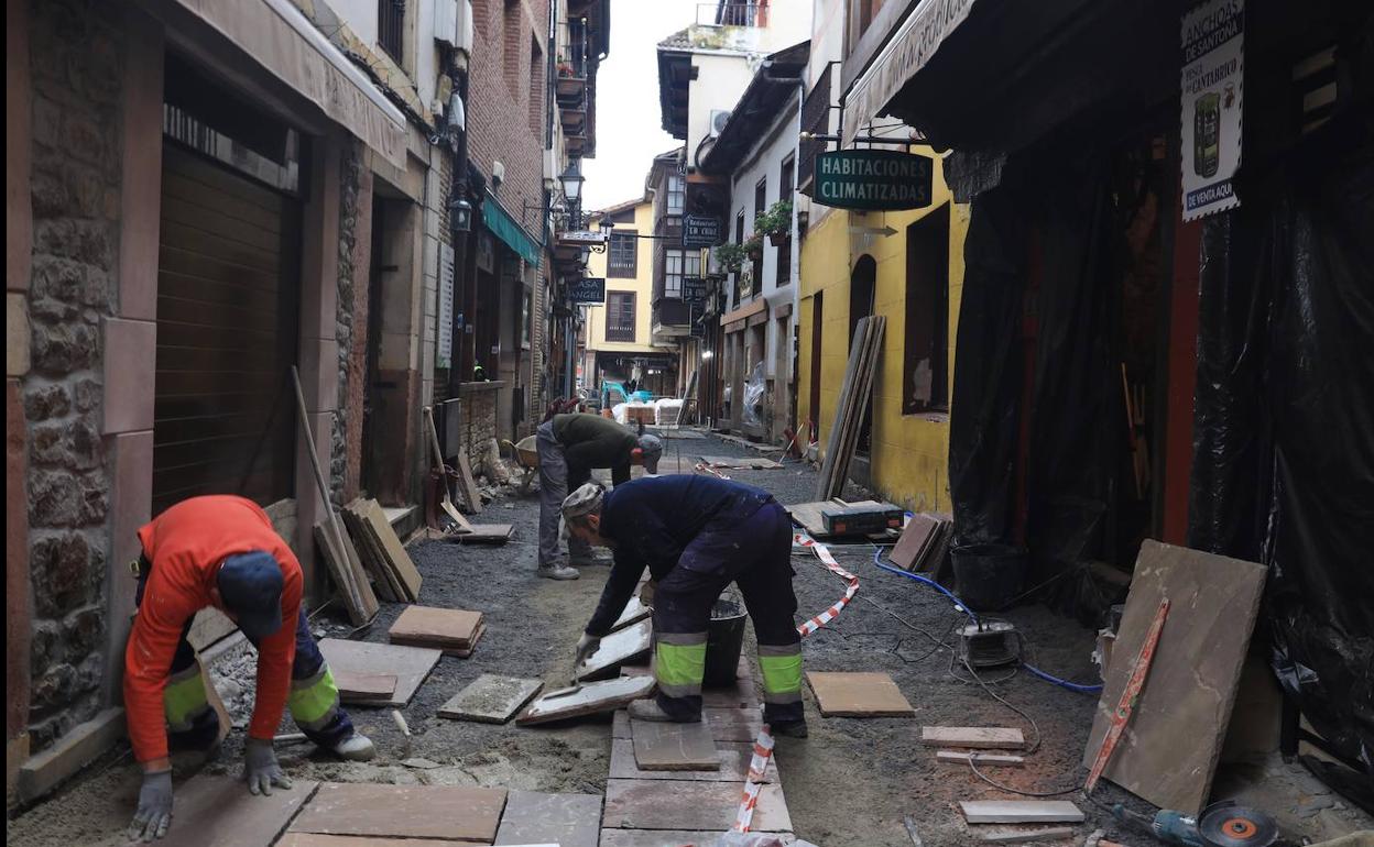 Un grupo de operarios trabaja en la renovación del pavimento de la calle Cántabra, en el centro de Potes. 