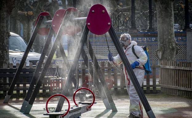 Imagen. Un operario desinfecta los columpios en el parque de La Alameda, muy cerca del ayuntamiento de colindres, en torno a las once de la mañana