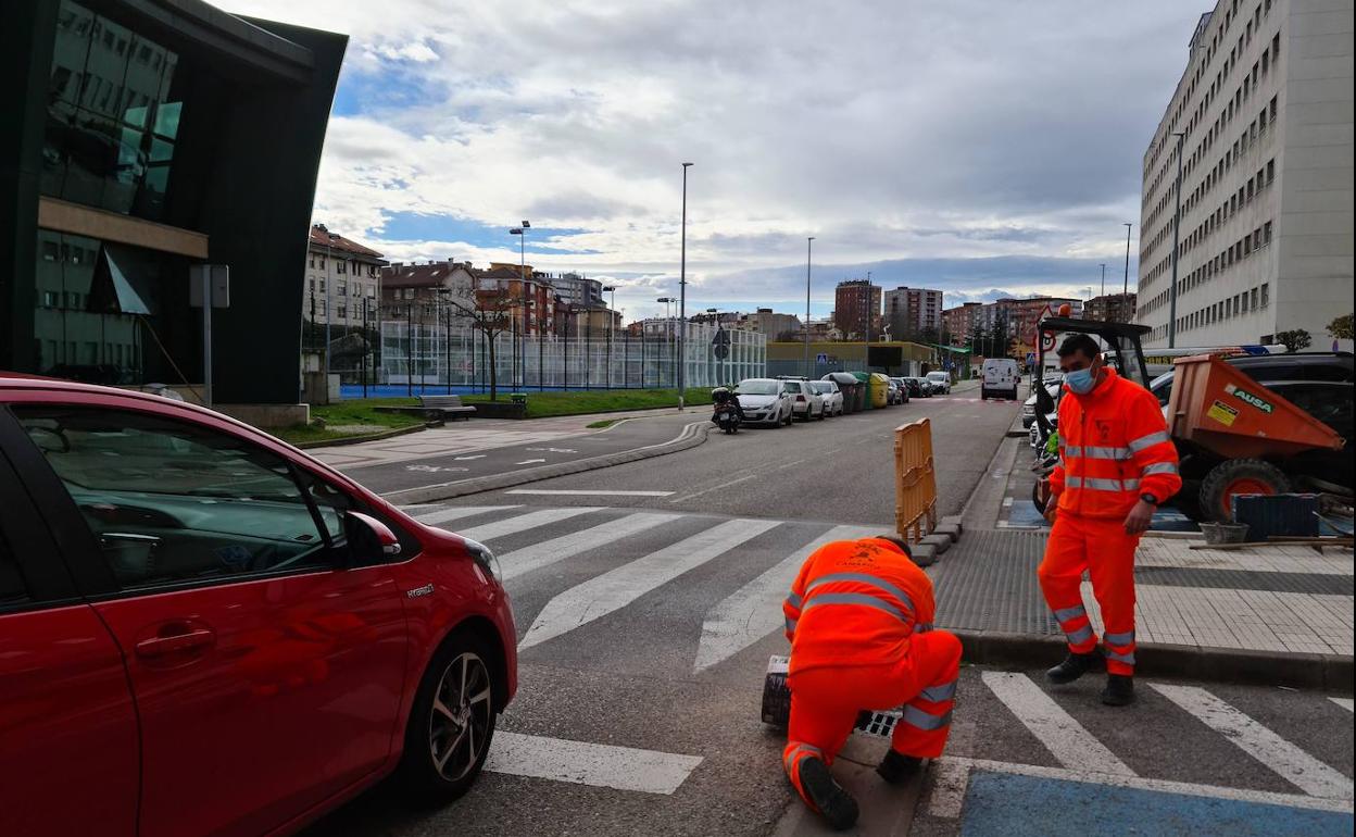 Dos operarios trabajan realizando un alivio en las tuberías de la calle Julio de Pablo, este martes, en Maliaño (Camargo).