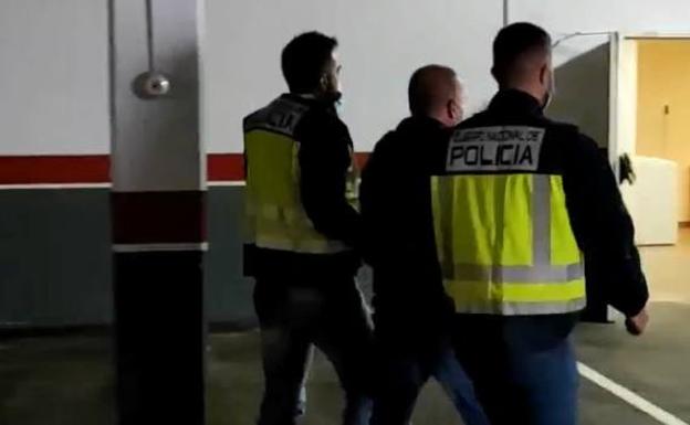 El detenido, flanqueado por los policías en el aparcamiento de la Jefatura Superior.