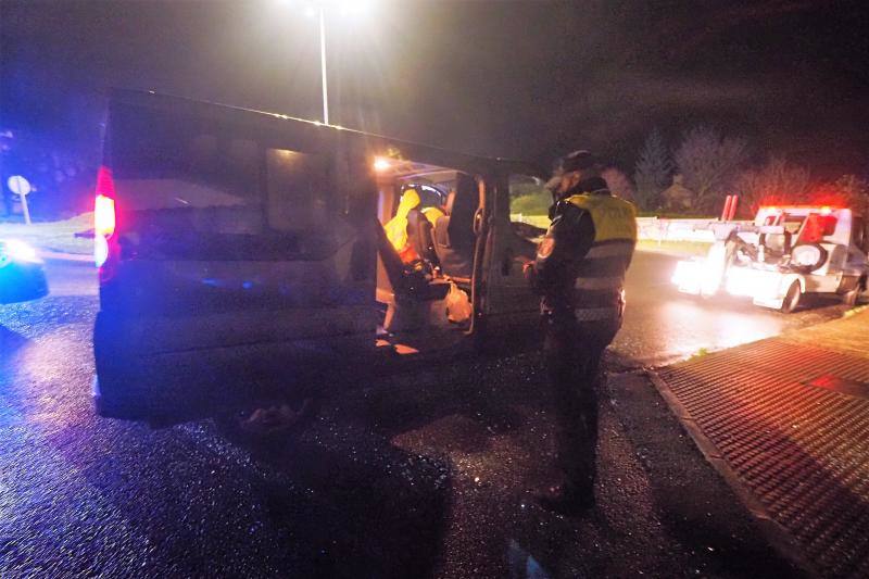 Agentes de la Policía Local inspeccionan la furgoneta después de detener a su conductora en la rotonda de Solares, donde se estrelló, tras una persecución desde Santander.