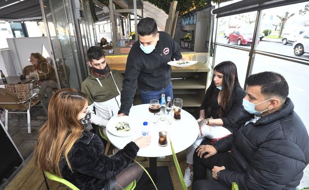 Juan López y sus tres amigos, este viernes, mientras el camarero del restaurante Almafiera les sirve.