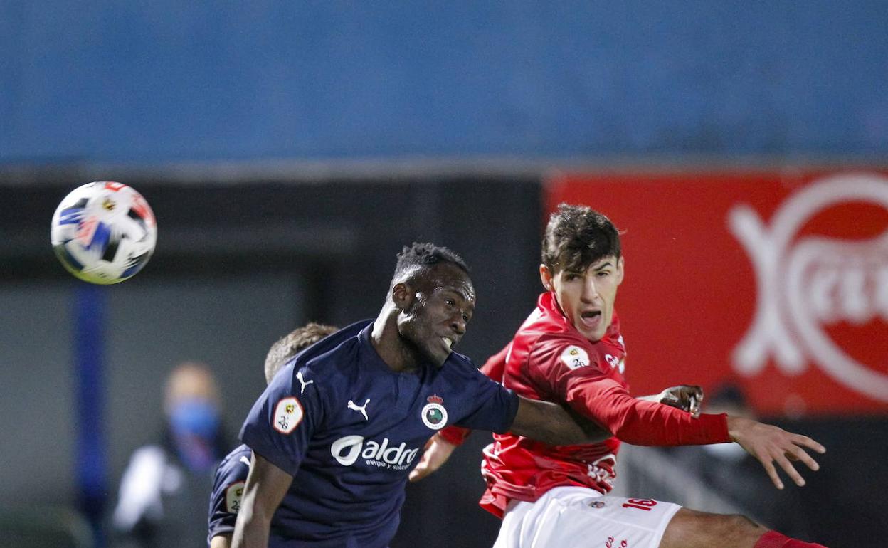 El racinguista Nana salta por un balón aéreo con el central del Laredo, Borja Ares, en el partido de ida. El zaguero del Charles no estará en el derbi por lesión. 