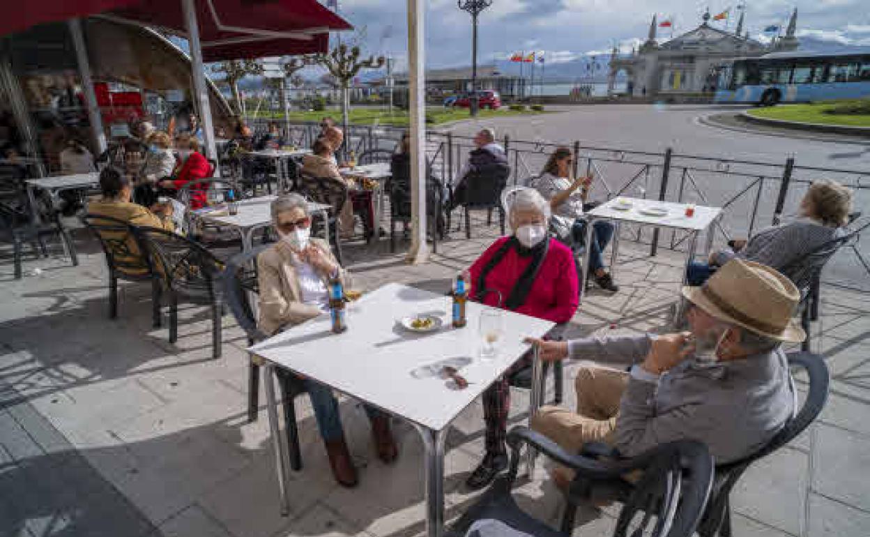 Los clientes de un bar de Santander consumen en la terraza ante el cierre de los interiores de la hostelería.