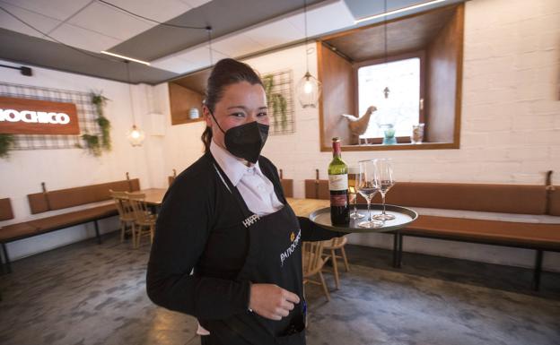 Patricia Ibáñez, camarera en Patiochico, lleva una bandeja con las bebidas.