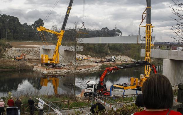 Maniobra realizada ayer para izar y colocar la gran estructura central de la pasarela sobre el río, con la ayuda de tres grúas. 