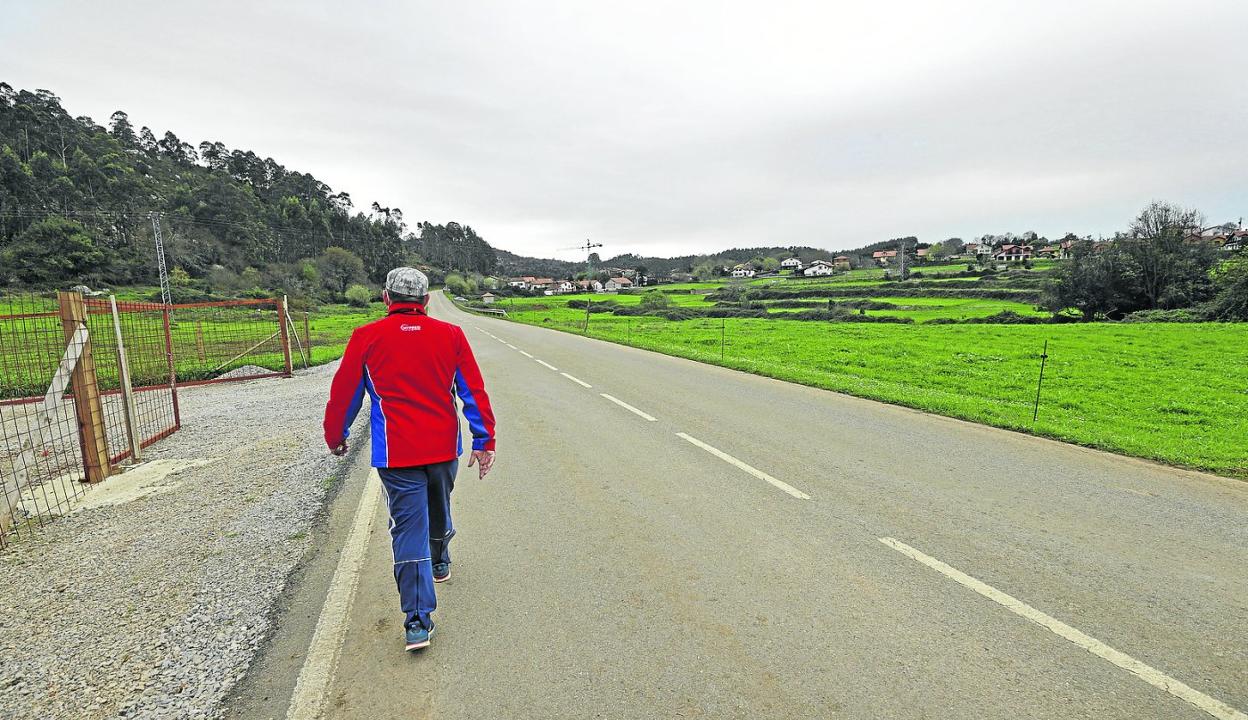 Un hombre recorre a pie la distancia de un kilómetro entre los barrios de la Iglesia y Ruilobuca, en el municipio de Ruiloba. 