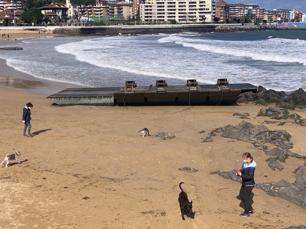 Los soldados retiran partes de los pontones encallados en la cala del Pocillo del Fraile para aligerar la maniobra de retirada de estas estructuras, desprendidas del puerto flotante instalado por el Ejército en unas maniobras desplegadas en Castro Urdiales. Otras piezas han acabado varadas en la playa de Brazomar, generando gran expectación.