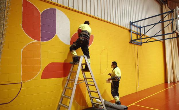 Dos pintores trabajan en la decoración del pabellón María Pardo. 