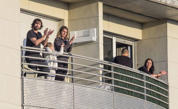 Varios vecinos aplauden desde sus balcones en la cita de las ocho.