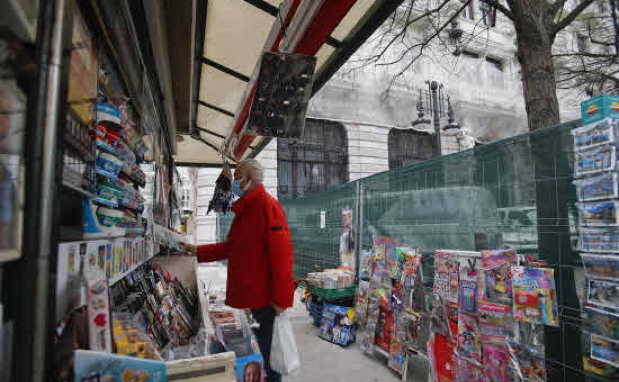 Un cliente compra un periódico en uno de los quioscos del centro de Santander