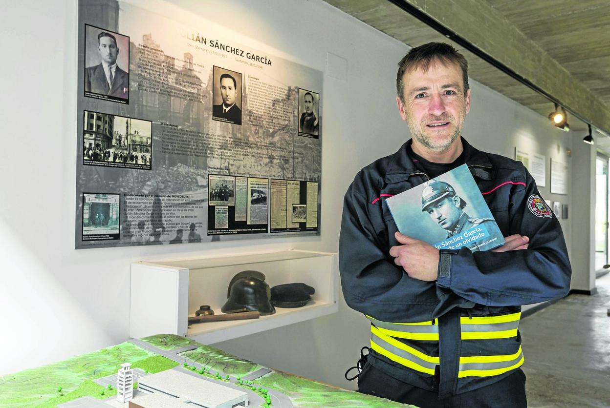 González Zarzuelo, con su libro, en el Parque de Bomberos de Ojaiz, delante del cartel que resume la historia de Julián Sánchez.