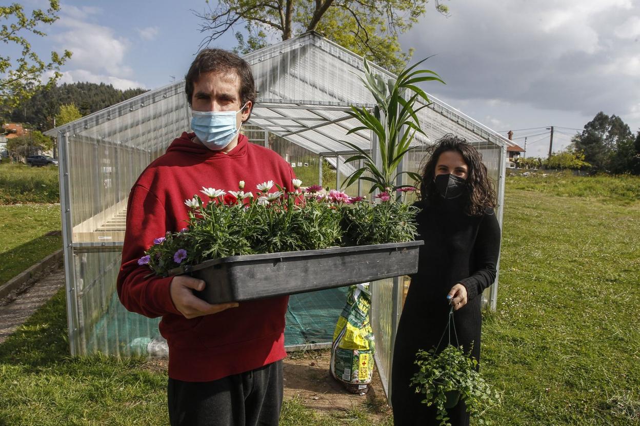 Roberto Ruiz, junto a la psicopedagoga Lorena López, en el invernadero de la asociación en Torrelavega.