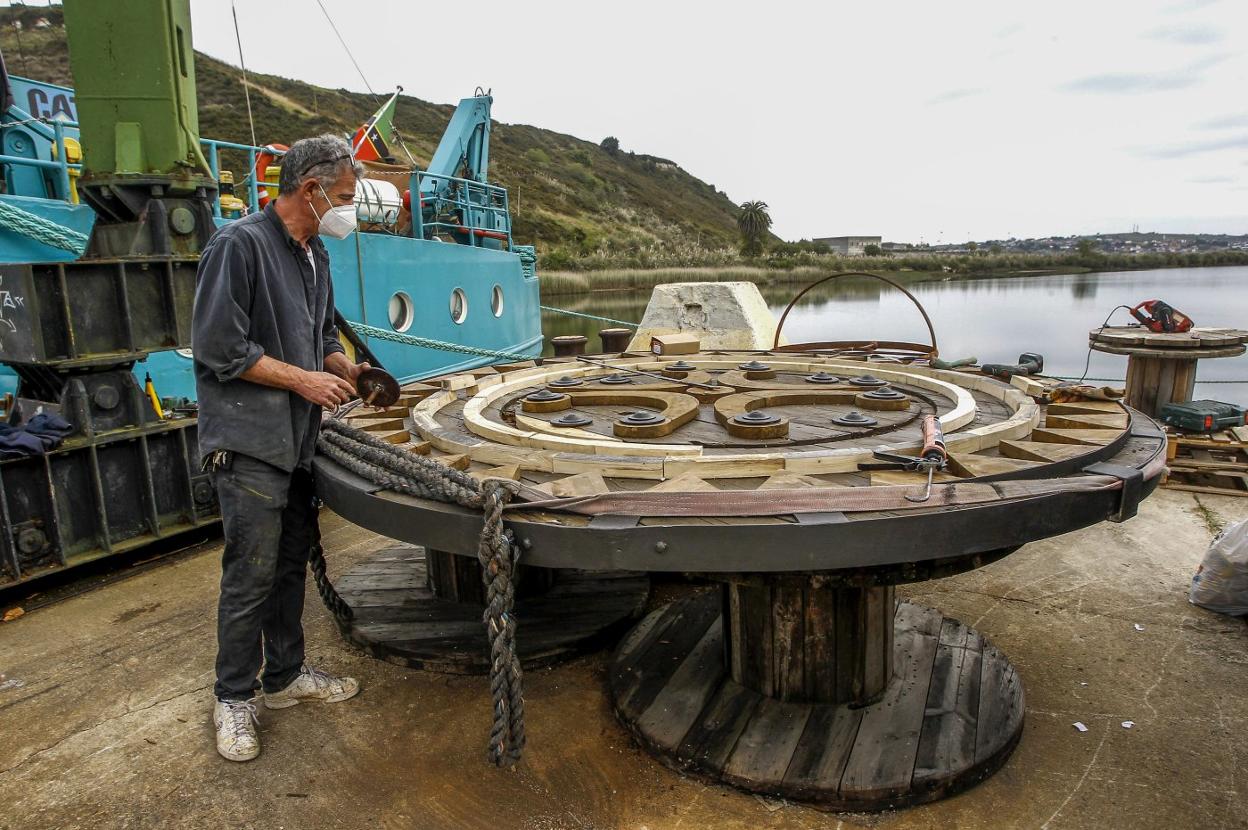 El escultor Pol Camps dando forma a una gran estela cántabra hecha con bobinas antiguas del puerto deshechadas. 