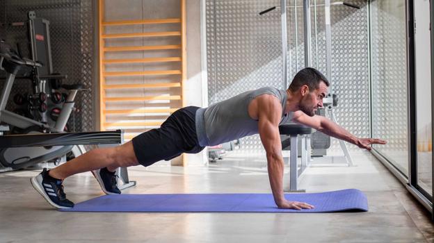 Plancha con dificultad añadida de extensión de brazo para trabajo de 'core'.