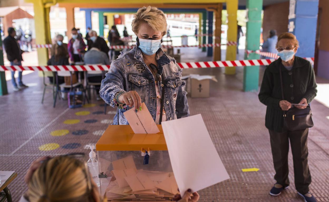 Una mujer vota, ayer, en un colegio público de Puente de Vallecas nada más abrir las urnas.