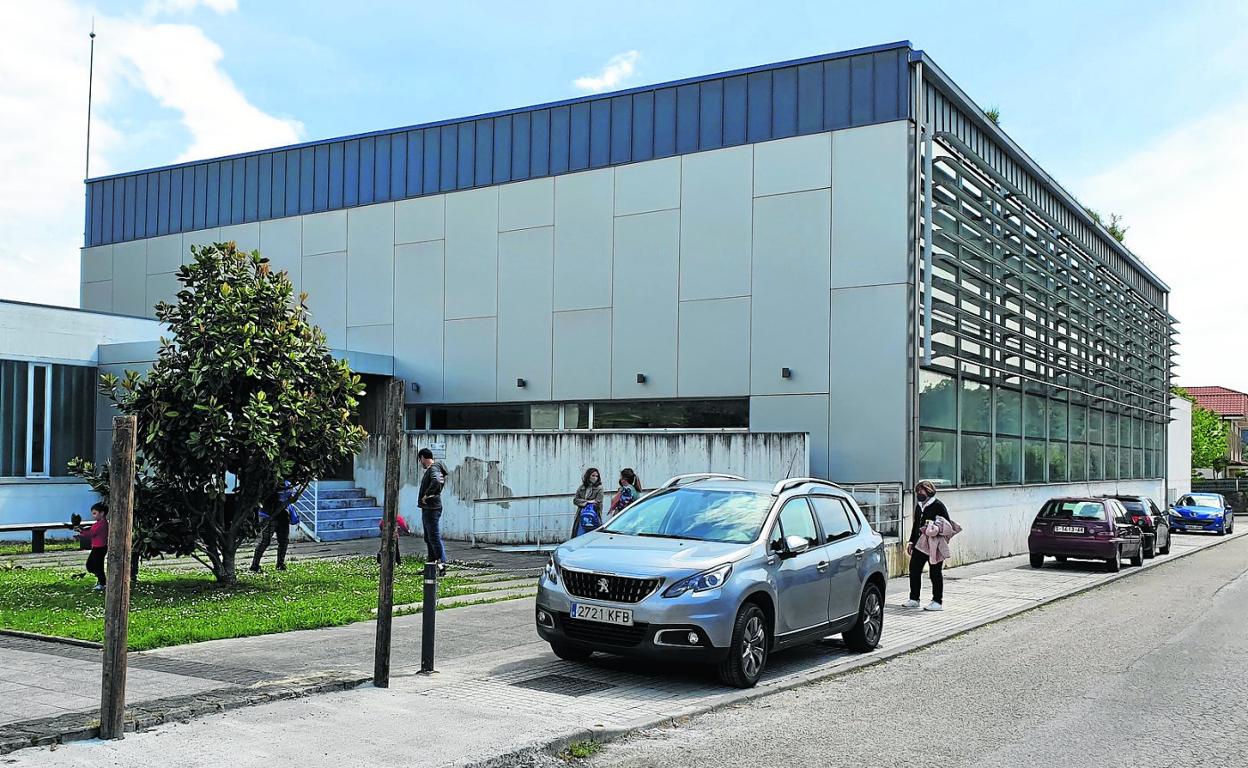 Los niños juegan junto a la edificación a la salida del colegio, que se encuentra al otro lado de la estrecha carretera. 