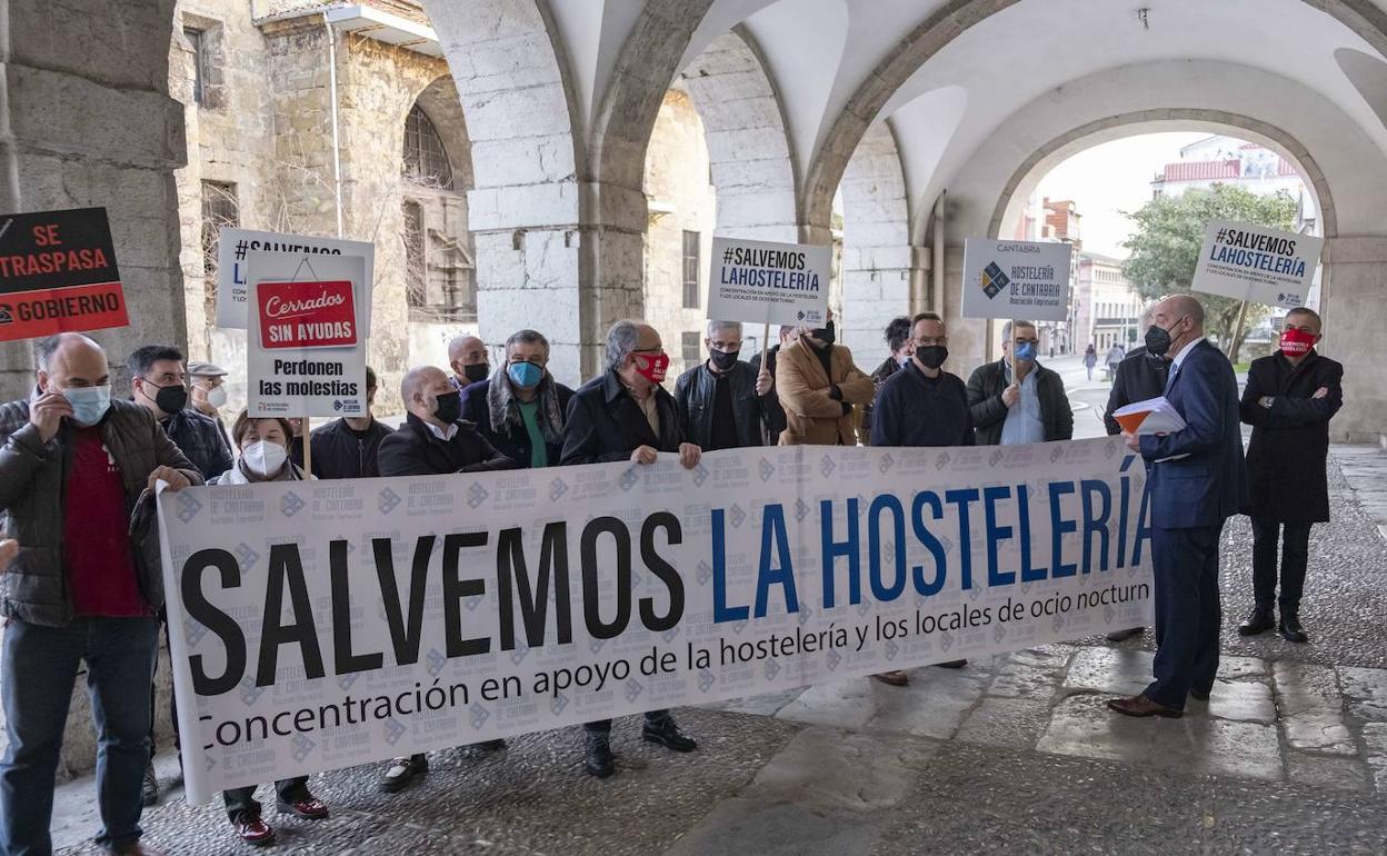 El diputado Félix Álvarez conversa con hosteleros en una concentración ante el Parlamento.