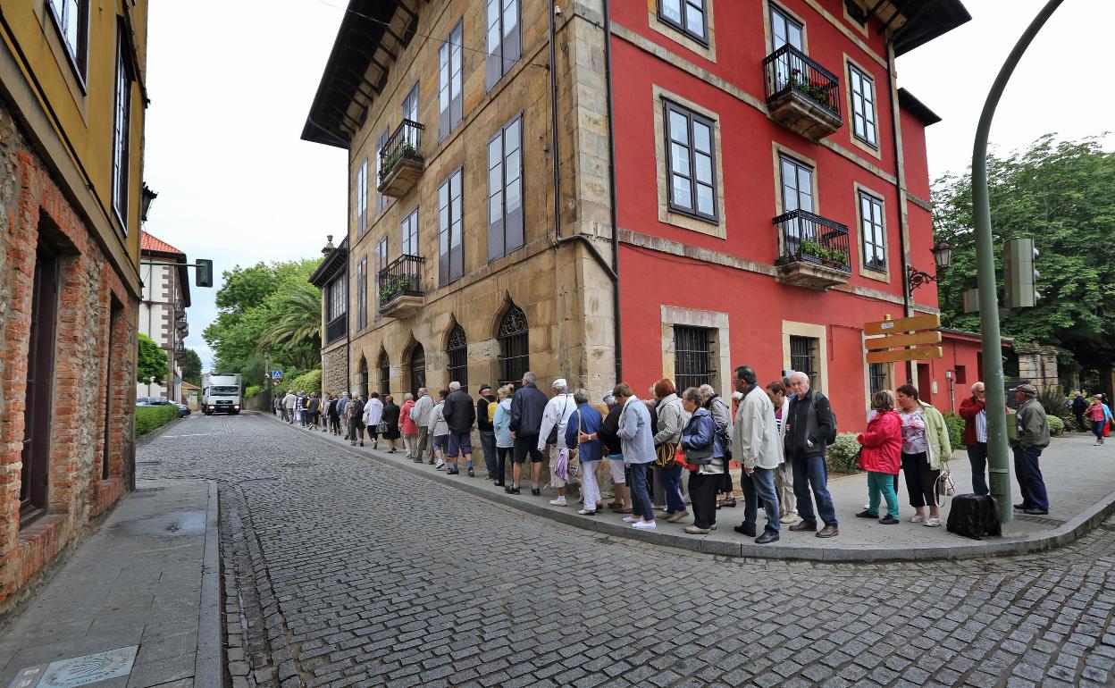 Una excursión de personas mayores transita por el centro de Comillas. 