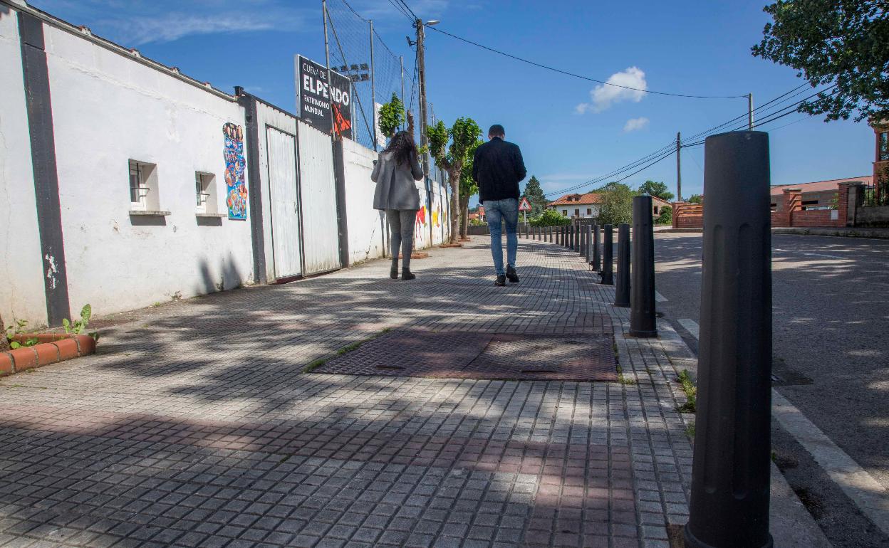 Dos personas caminan por la acera junto al campo de fútbol Eusebio Arce, esta semana, en Escobedo. 
