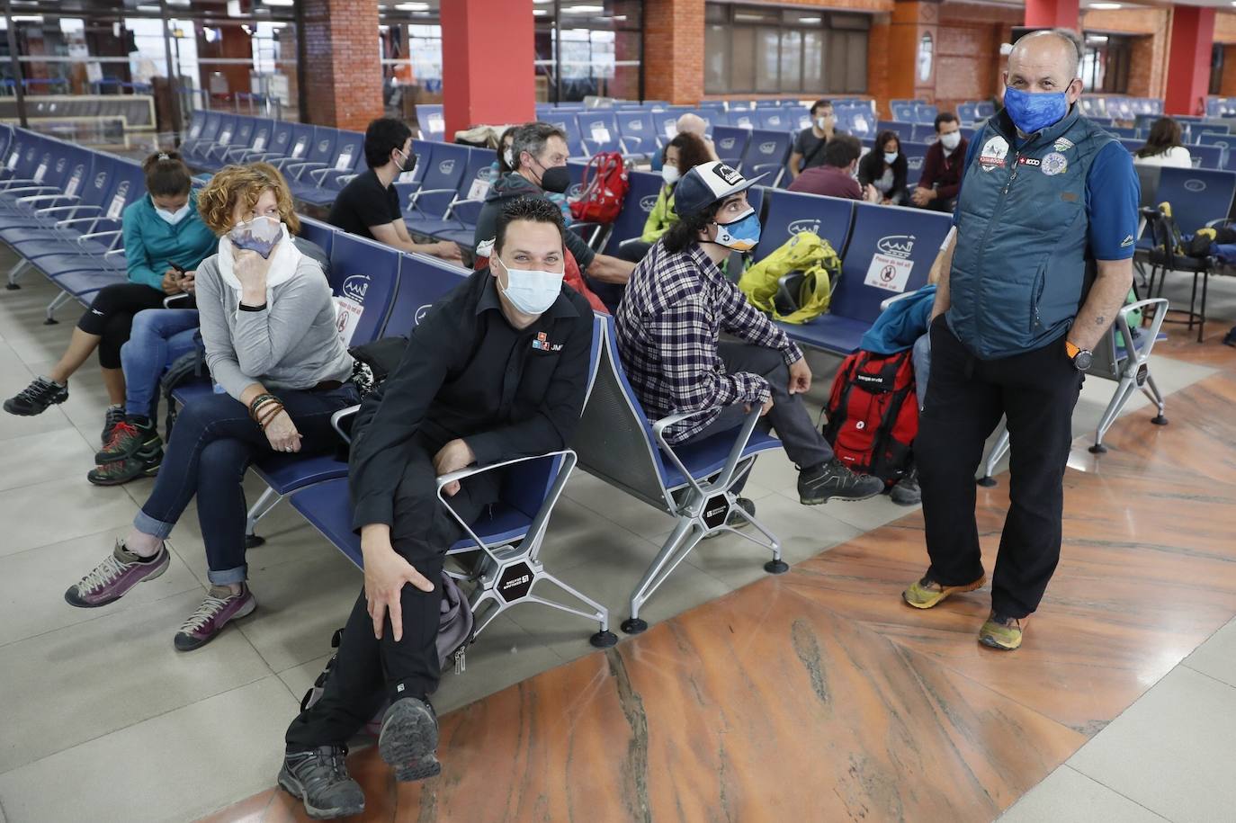 El alpinista Juanito Oiarzabal (c), entre otros alpinistas, posa en la sala de embarque antes de partir hacia España, este viernes. España ha organizado un vuelo especial de Iberia que viajajó este miércoles a Katmandú cargado de material médico y sanitario para regresar el viernes con un centenar de alpinistas españoles y de otros países de la Unión Europea atrapados en Nepal a consecuencia del coronavirus. Entre el centenar de españoles atrapados están el veterano himalayista Carlos Soria y Sebastián Álvaro, director del programa de TVE 'Al filo de lo imposible' , quien se encuentra con el conocido alpinista Juanito Oiarzabal y un grupo de 27 personas, que han contactado con Exteriores para intentar regresar a España.