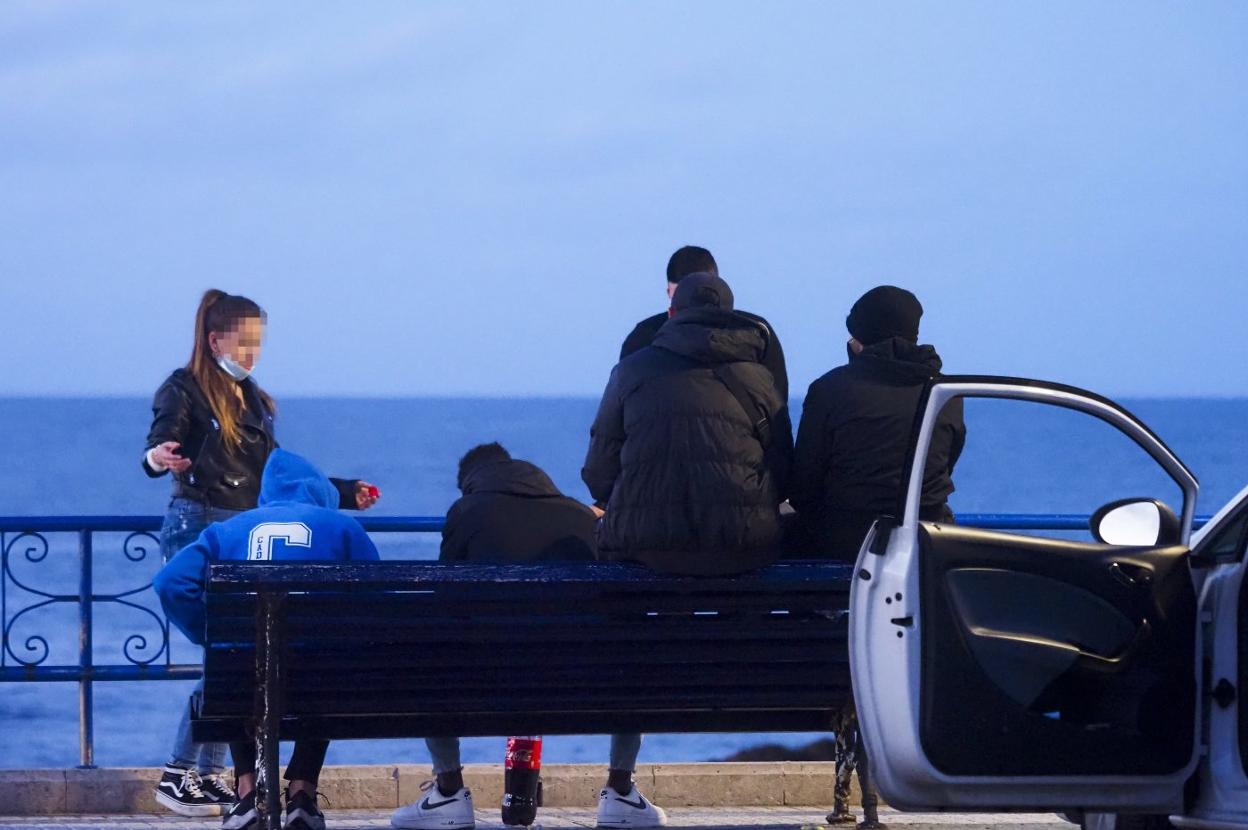 Grupo de jóvenes en el aparcamiento de la playa de El Camello, en Santander.