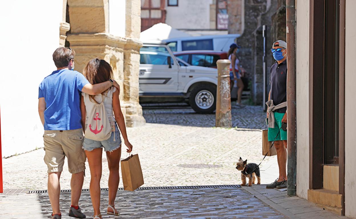 Una pareja pasea por una de las calles del centro de la villa. 