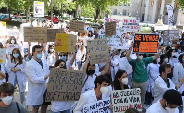 Varios sanitarios con carteles, participan en la manifestación convocada por la plataforma FSE Unida como protesta al sistema de adjudicación de plazas para el MIR