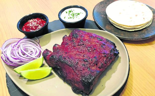 Imagen principal - Ariiba, tacos mexicanos de costilla lacada con salsa barbacoa casera y raita de aceitunas y pepinillo. Abajo, pulpo a la plancha con polvo de quicos y salsa ponzu y patata cocida y arroz negro del señorito con chipirones y gambas.