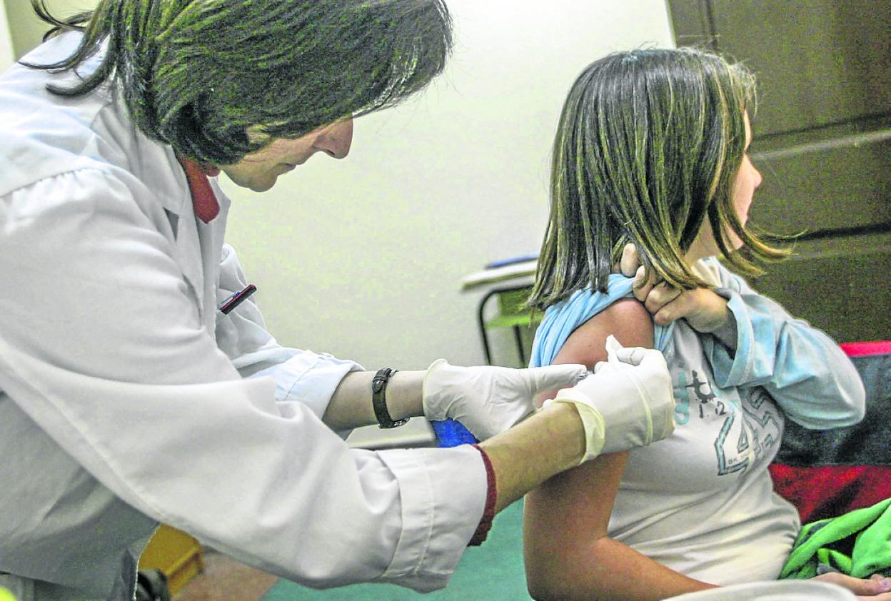 Una enfermera vacuna de meningitis a una adolescente, en una imagen de archivo. 