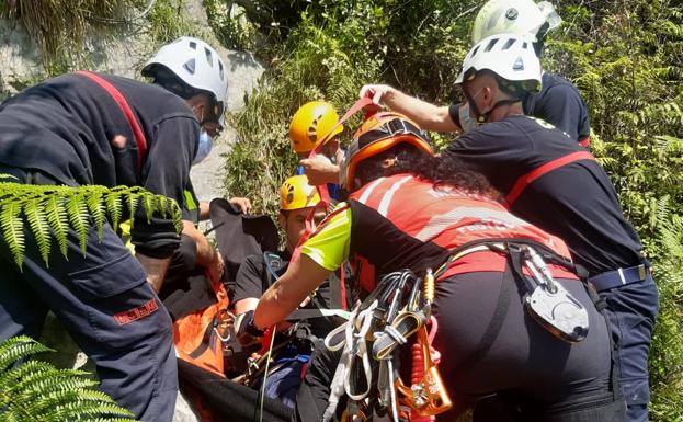 Los rescatadores, bomberos y sanitarios atienden al herido.