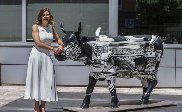 La consejera regionalista, junto a la escultura de una vaca ubicada frente a la sede del Gobierno.