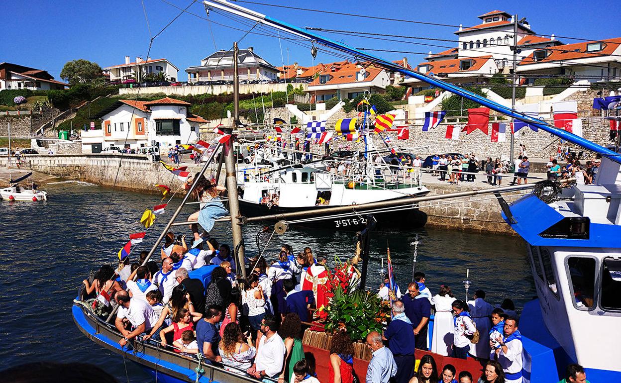 Los vecinos participan en la famosa procesión marítima en las fiestas del Cristo del Amparo de Comillas. 