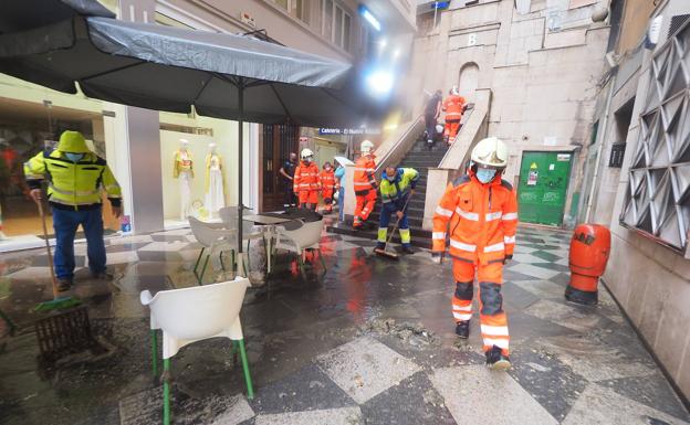 Imagen principal - Bomberos y personal municipal intentan quitar el agua en la calle Ruamayor.